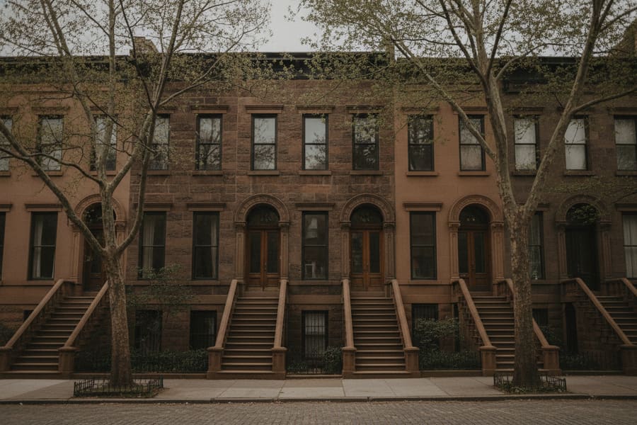 The parlour floor of a Brooklyn brownstone with original hardwood boards and tall shuttered windows