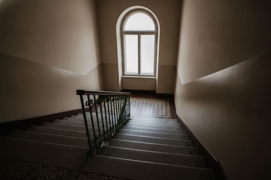 A narrow stairway inside a Brooklyn pre war walk up building with worn wooden treads